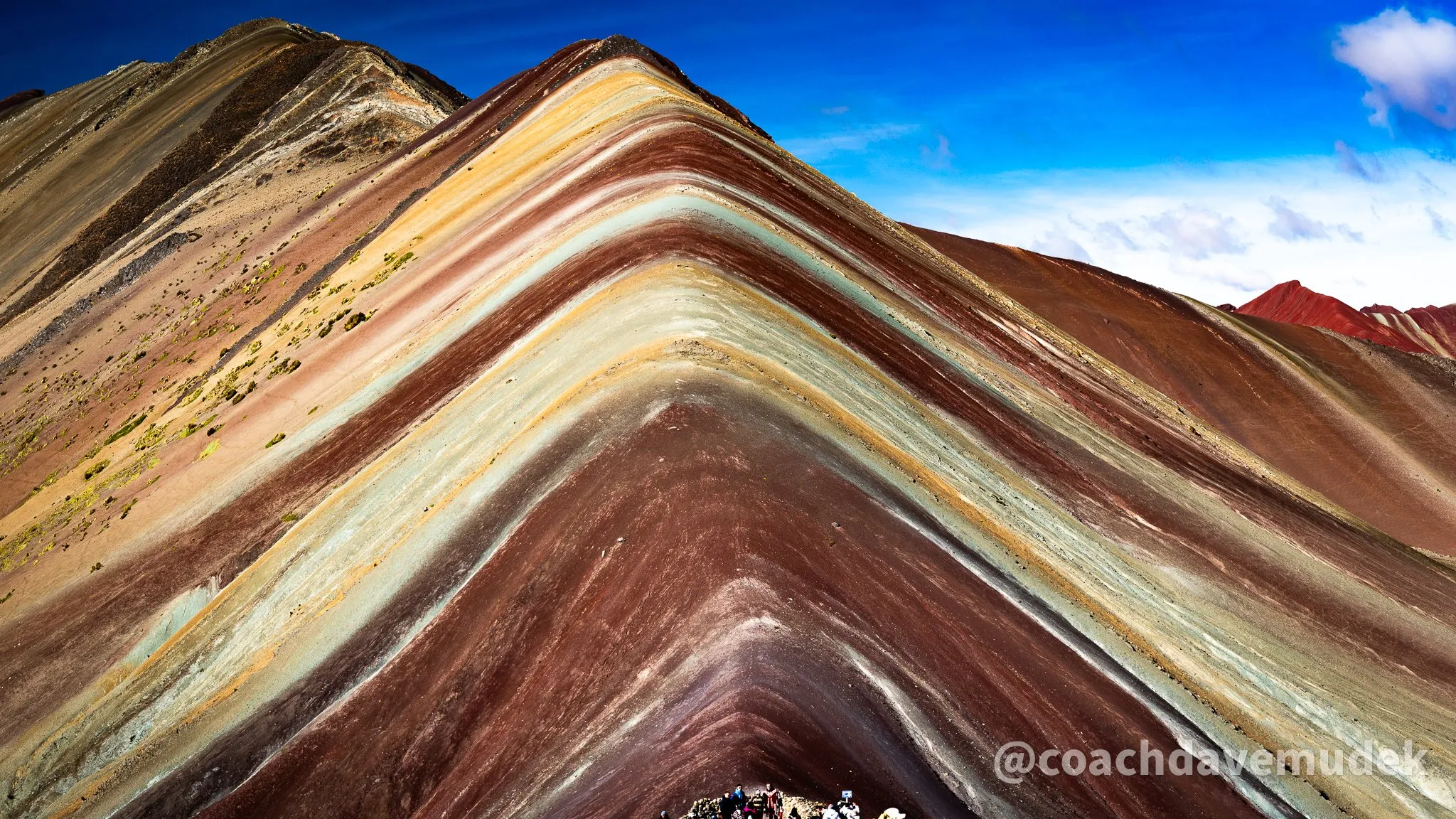 Rainbow Mountain in Peru, its striped slopes under a blue sky